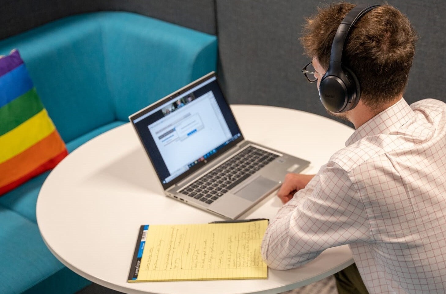 man in front of a laptop with headset