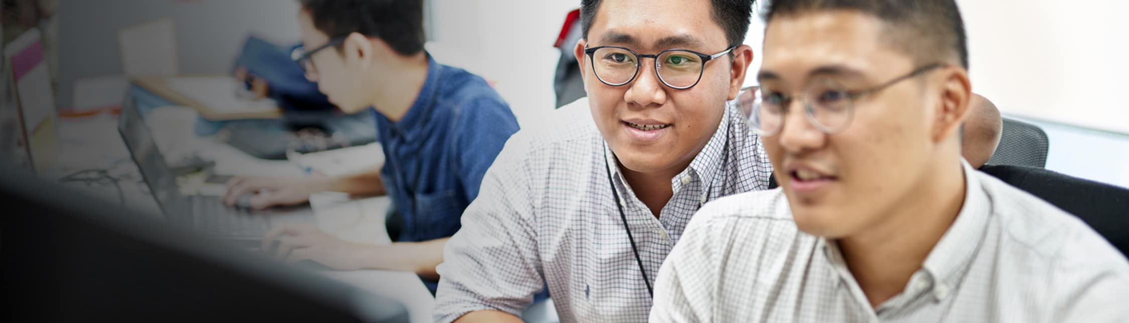 Two men at a computer banner