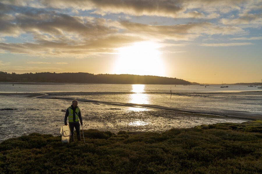 man-collecting-litter-on-a-beach