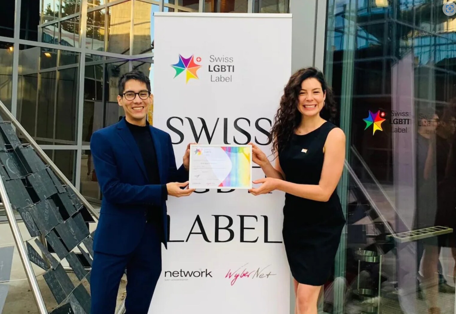 Two People holding the Swiss LGBTI Label